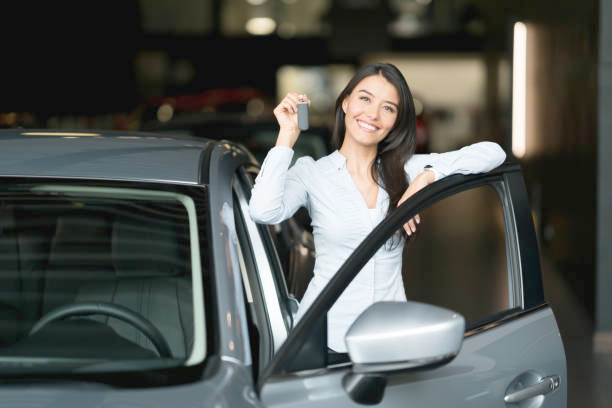 Happy family waving from inside their new car